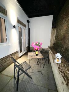 a patio with a table and a chair on a patio at Homes from home by Tulloch Properties in Maidstone