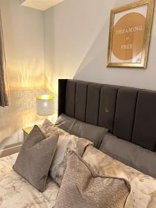- un lit avec des oreillers dans l'établissement Homes from home by Tulloch Properties, à Maidstone