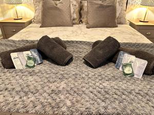 a bed with two pillows and towels on it at Homes from home by Tulloch Properties in Maidstone