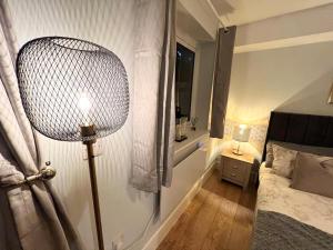 a room with a bed and a lamp in it at Homes from home by Tulloch Properties in Maidstone