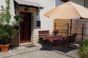 een tafel met een paraplu voor een huis bij Pri Matičku in Bohinj