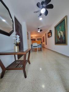 a living room with a table and a ceiling fan at R10 Lindo Apto de 5 recámaras, zona turística. in Panama City