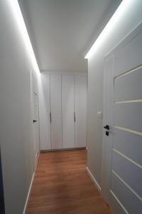 an empty closet with white doors and a wooden floor at Apartament Manhattan in Płock