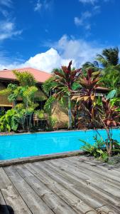 a resort with a blue swimming pool in front of a building at Domaine Karaibes in Deshaies