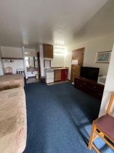 a room with a bed and a tv and a kitchen at Fairground Inn in Monroe