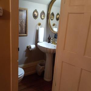 a bathroom with a sink and a mirror and a toilet at Governor's Corner Bed & Breakfast in Russellville