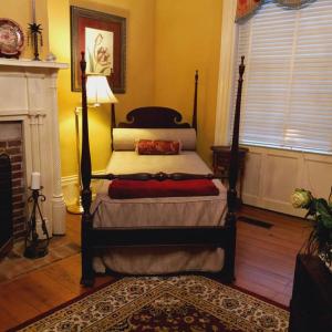 a bedroom with a bed in a room with a fireplace at Governor's Corner Bed & Breakfast in Russellville