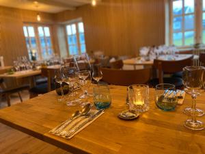 una mesa de madera con copas de vino y cubiertos en Mølin Guesthouse en Skálavík