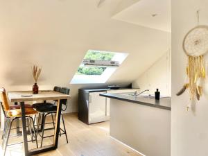 a kitchen with a table and a sink and a refrigerator at LE NID DES QUAIS - Vue Panoramique au cœur de la ville - Wifi - Entrée autonome in Quimper