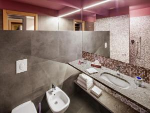 a bathroom with a sink and a toilet and a mirror at Hotel Da Vinci in Milan