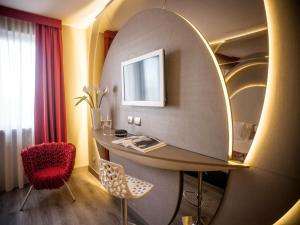 a room with a table and chairs and a mirror at Hotel Da Vinci in Milan