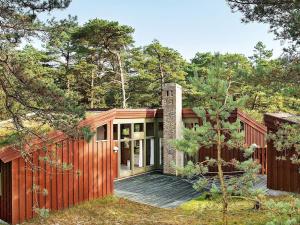a wooden house in the middle of the forest at Three-Bedroom Holiday home in Nexø 38 in Vester Sømarken