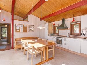 Vester SømarkenにあるThree-Bedroom Holiday home in Nexø 38の木製テーブルと椅子付きの広いキッチン