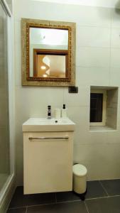 uma casa de banho com um lavatório branco e um espelho. em Al Civico Quattro - Studio Flat em Ischitella