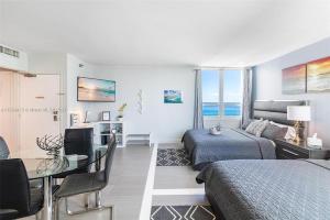 1 dormitorio con 1 cama, 1 mesa y 1 habitación en 11th - Seven Heaven Miami- Unforgettable Ocean Front- Free Parking, en Miami Beach