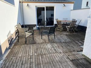 un patio avec des chaises et une table sur une terrasse dans l'établissement Les Cerises, charmante maison au calme, à Wavre