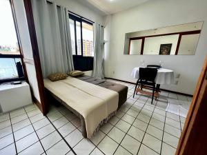 1 dormitorio con 1 cama y 1 mesa en una habitación en Apto completo na orla da Pituba!, en Salvador