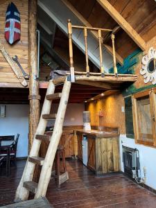 a loft bed in a log cabin with a kitchen at Ma-hai in Ushuaia