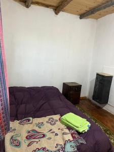 een slaapkamer met een bed met een deken erop bij Ma-hai in Ushuaia