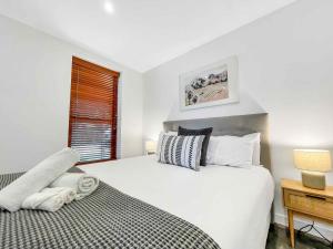 Un dormitorio con una gran cama blanca y una ventana en Two Doors en Broke