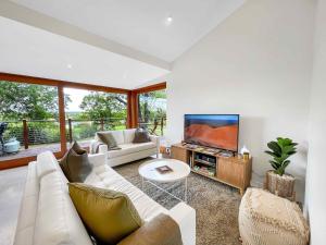 a living room with a white couch and a tv at Two Doors in Broke