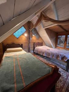 twee bedden in een kamer met een zolder bij Ma-hai in Ushuaia