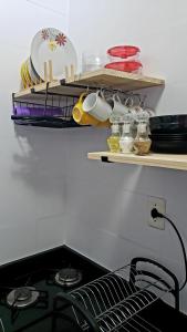 un estante sobre una estufa con platos y tazones. en Flat Barra en Salvador