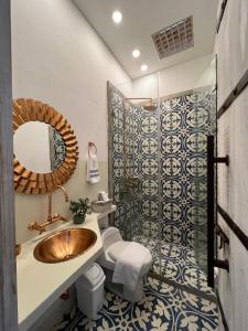 a bathroom with a sink and a toilet and a mirror at MAHI CASA BOUTIQUE in Cali