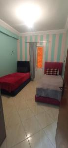 ein Wohnzimmer mit 2 Betten und einem Fenster in der Unterkunft Darna in Agadir