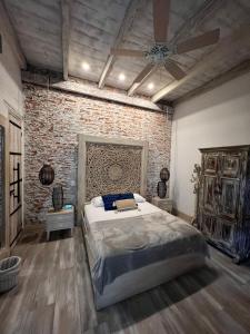 um quarto com uma cama grande e uma parede de tijolos em MAHI CASA BOUTIQUE em Cali