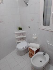 Baño blanco con aseo y lavamanos en La vie en rose, en Mola di Bari