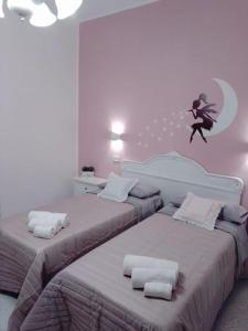 un dormitorio con dos camas con una chica saltando a la luna en La vie en rose, en Mola di Bari