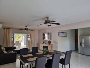 sala de estar con ventilador de techo, mesa y sillas en Villa Hye en Willemstad