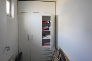 a white closet with white cabinets in a room at Studio K2 in Skopje