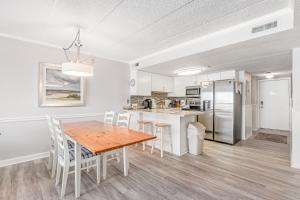 a kitchen and dining room with a wooden table and chairs at Summer Beach 506 in Ocean City