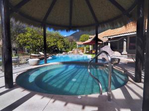 a swimming pool with an umbrella on top of it at Aranwa Sacred Valley Hotel & Wellness in Urubamba