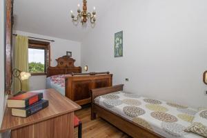 a bedroom with two beds and a table and a window at Marija-Lorena in Gora Glušići (Haus für 4-5 Personen) in Labin