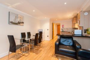 a living room with a dining room table and chairs at London Serviced Apartments in London