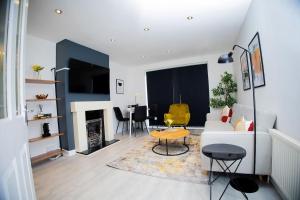 een woonkamer met een witte bank en een tafel bij Isinmi Home - Close to MCR City in Manchester