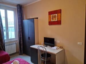 um quarto com uma secretária, um computador e um frigorífico em Hostel Mosaic em Roma