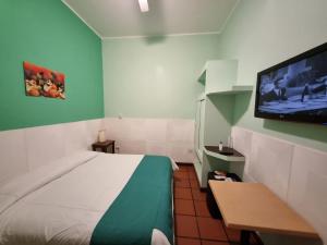 Habitación pequeña con cama y TV de pantalla plana. en Refugio del Inca en Salta