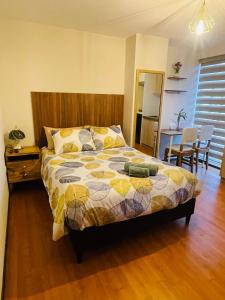 1 dormitorio con 1 cama, mesa y sillas en Estudio acogedor y elegante, en Cochabamba