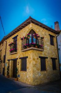 Arbancón的住宿－Casa Rural Las Albertas，一座石头建筑,设有花箱和窗户