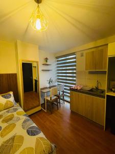 1 dormitorio con 1 cama y cocina con mesa en Estudio acogedor y elegante, en Cochabamba