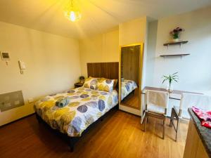 1 dormitorio con cama, escritorio y mesa en Estudio acogedor y elegante, en Cochabamba