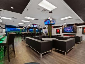 a restaurant with couches and tables and televisions at Best Western Plus Cairn Croft Hotel in Niagara Falls