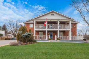 een rood bakstenen huis met een vlag in de voortuin bij Best Western Colonel Butler Inn in Niagara on the Lake