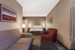 um quarto de hotel com uma cama e duas cadeiras em Best Western Colonel Butler Inn em Niagara-on-the-Lake