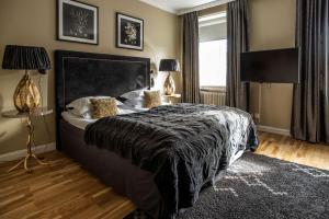 a bedroom with a large bed with a black blanket at V Hotel Helsingborg; BW Premier Collection in Helsingborg