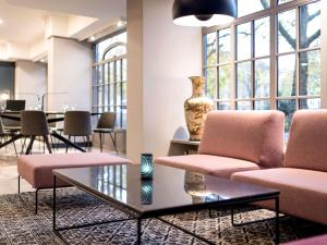 a lobby with two chairs and a vase on a table at Mercure Mainz City Center in Mainz